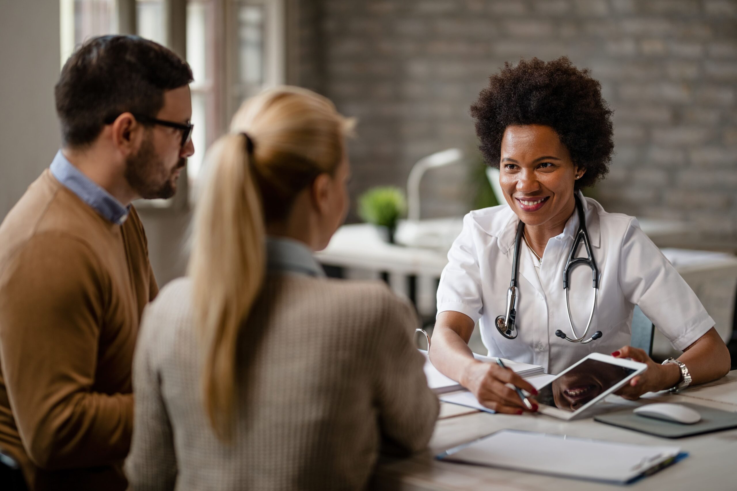 médica feliz realizando a gestão de pacientes em sua clínica