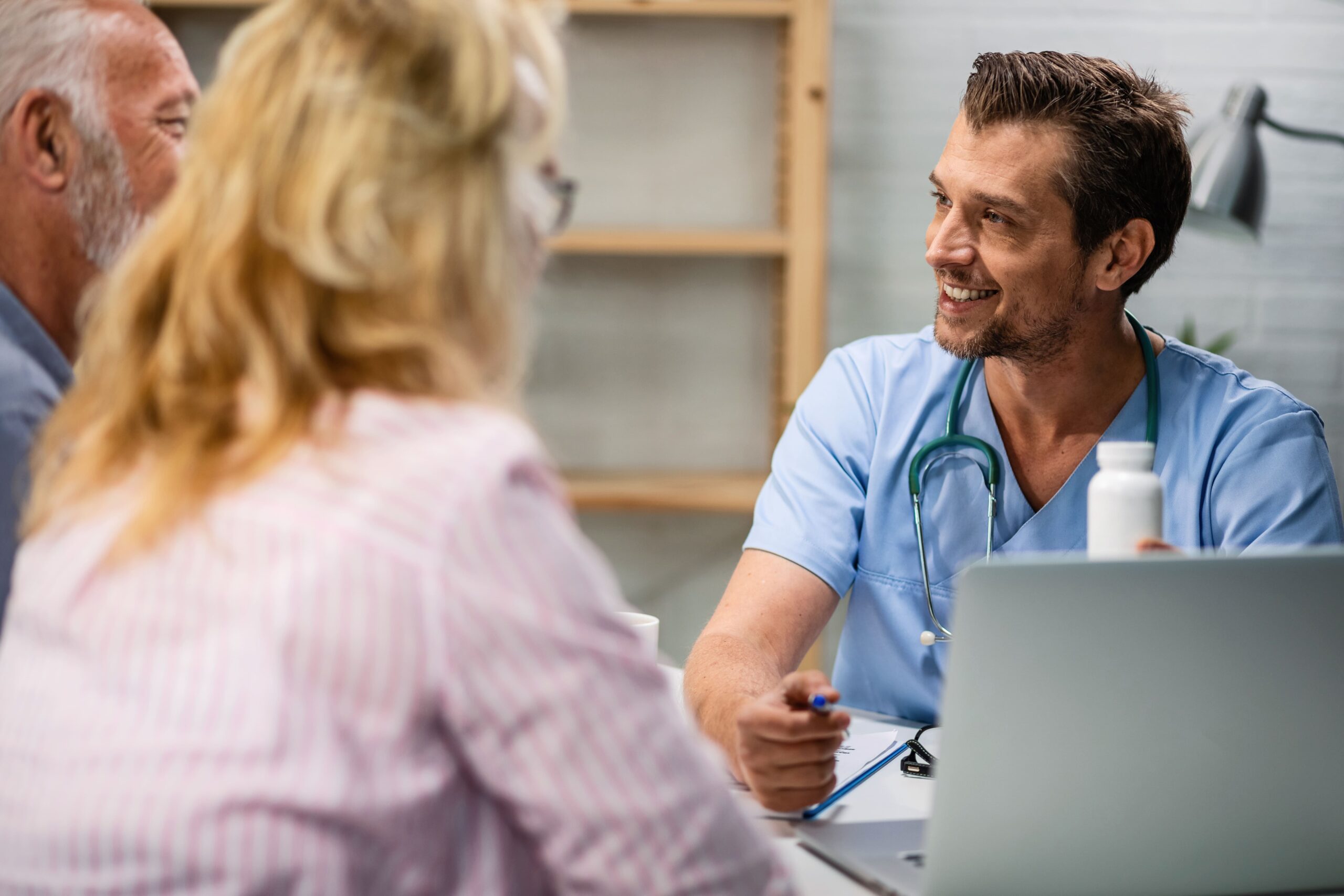 médico sorrindo para os pacientes e melhorando a experiência deles com o Versatilis System