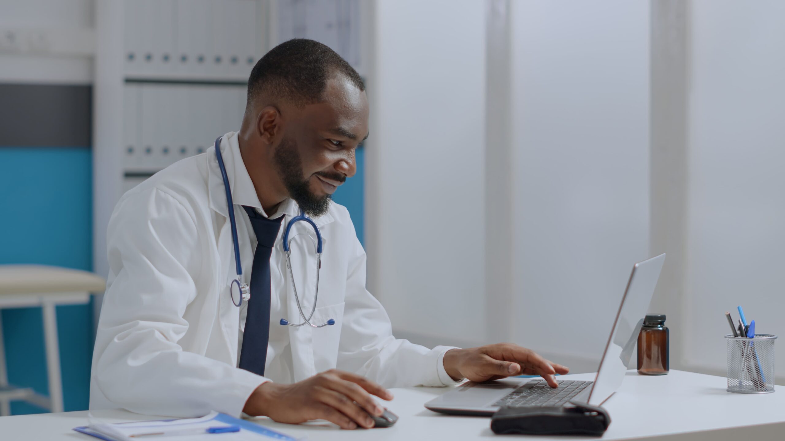 médico negro em frente a um computador