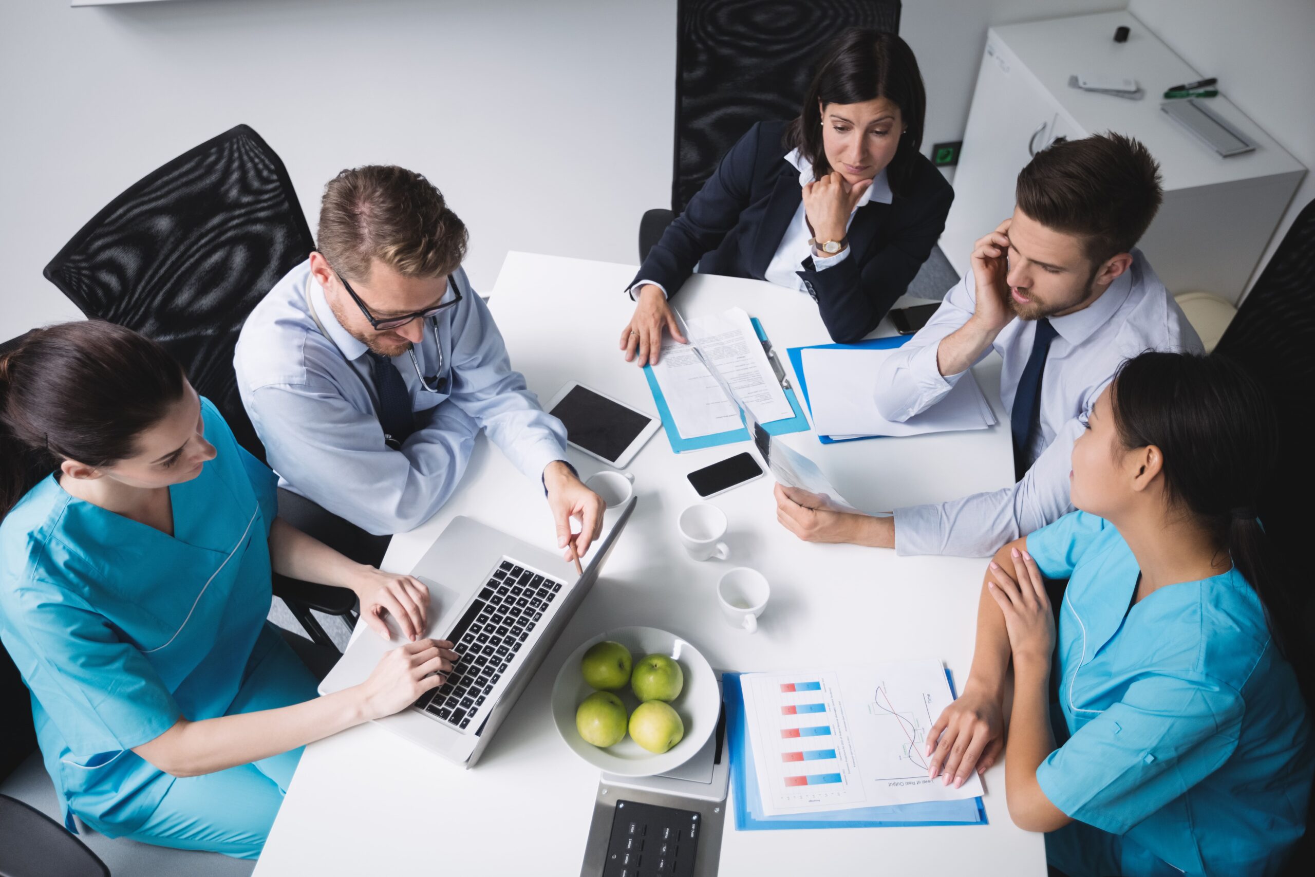 time de profissionais reunidos ao redor de uma mesa fazendo o planejamento estratégico da clínica