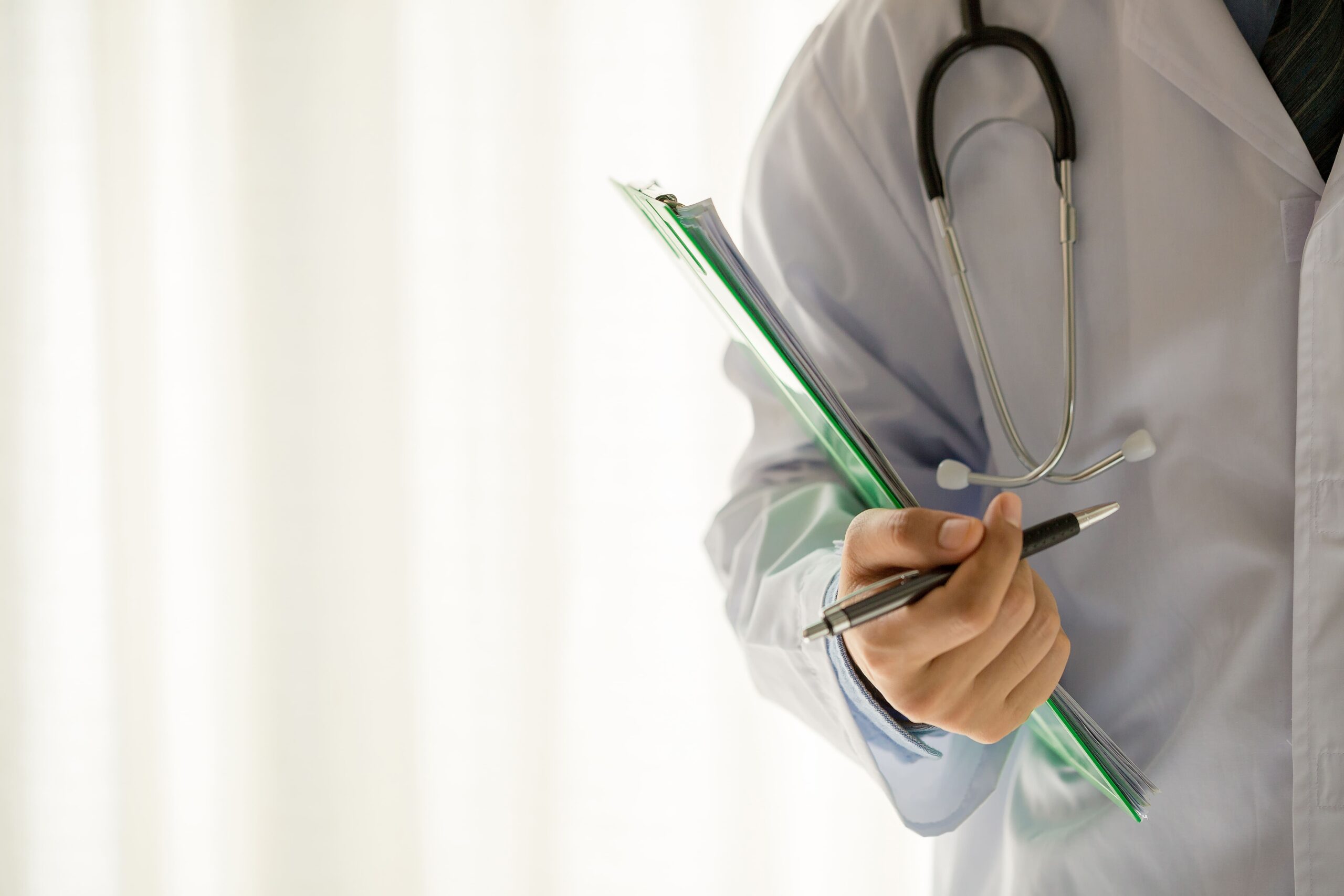 médico segurando uma prancheta e com um estetoscópio no pescoço