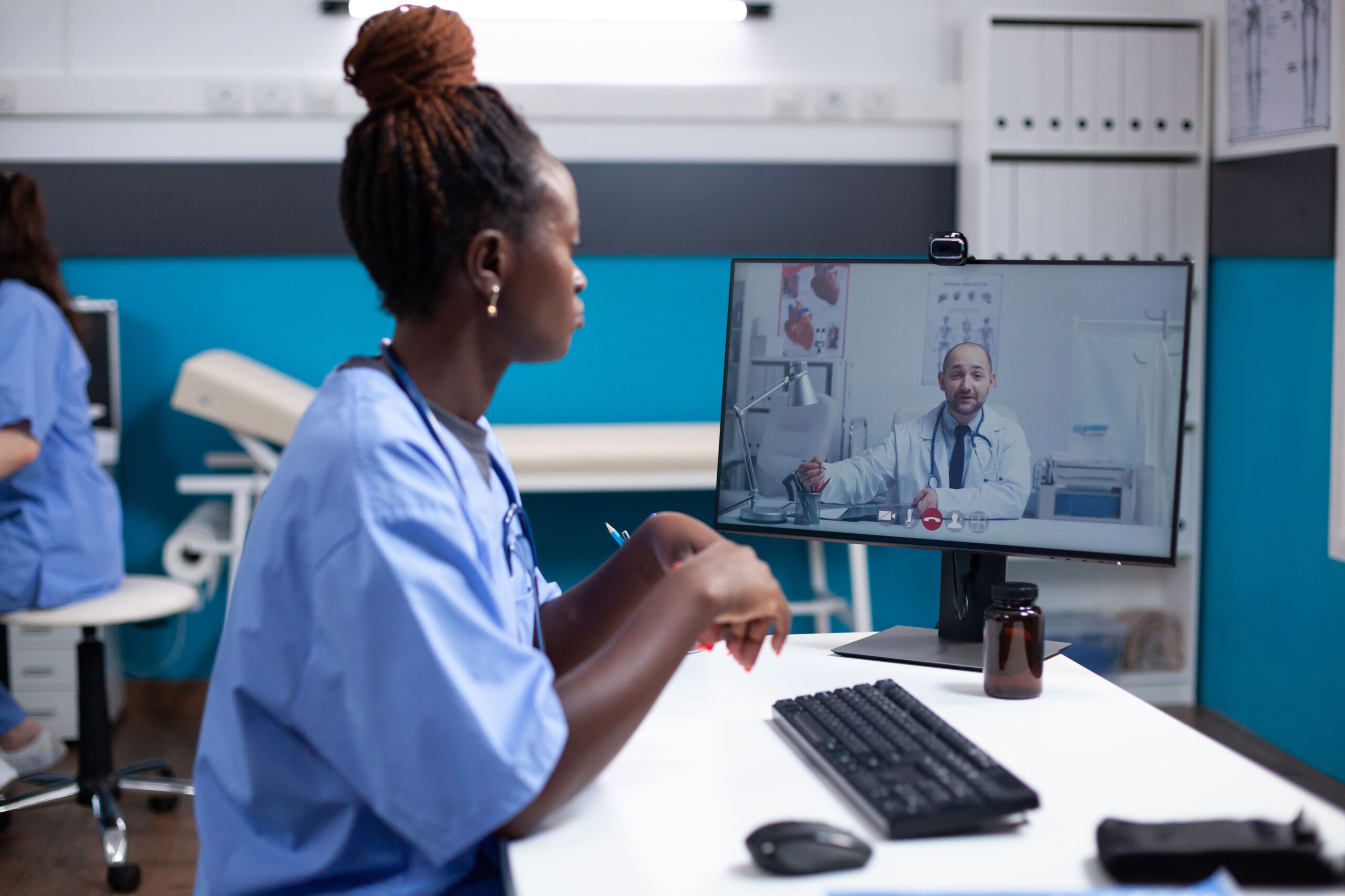 profissionais da saúde no computador realizando o processo de teletriagem